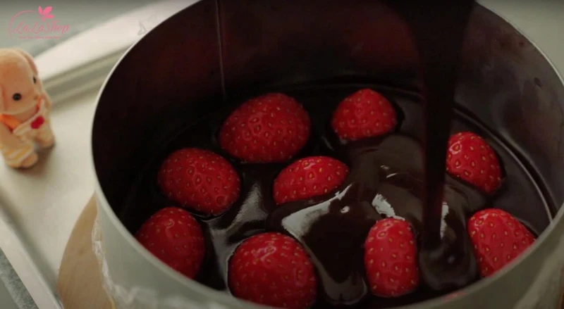 Cho chocolate vừa đun vào khuôn và xếp dâu tây