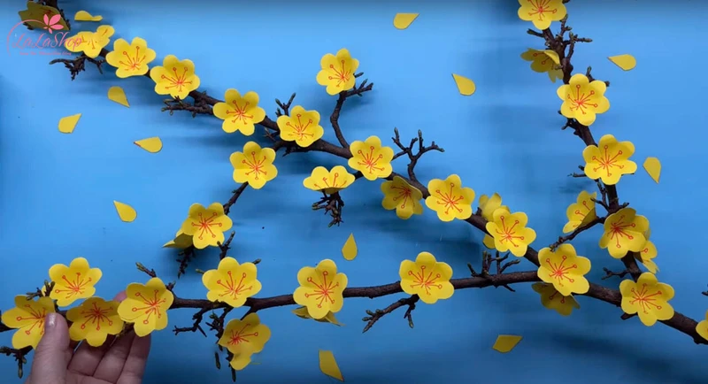 Dán hoa mai vào cành