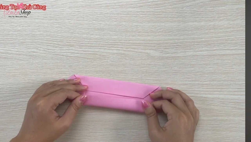 Gấp 2 cạnh ngang vào nếp gấp ban đầu